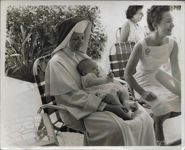 Sister Margaret Joseph Smith holding a baby during Alumni Family Day